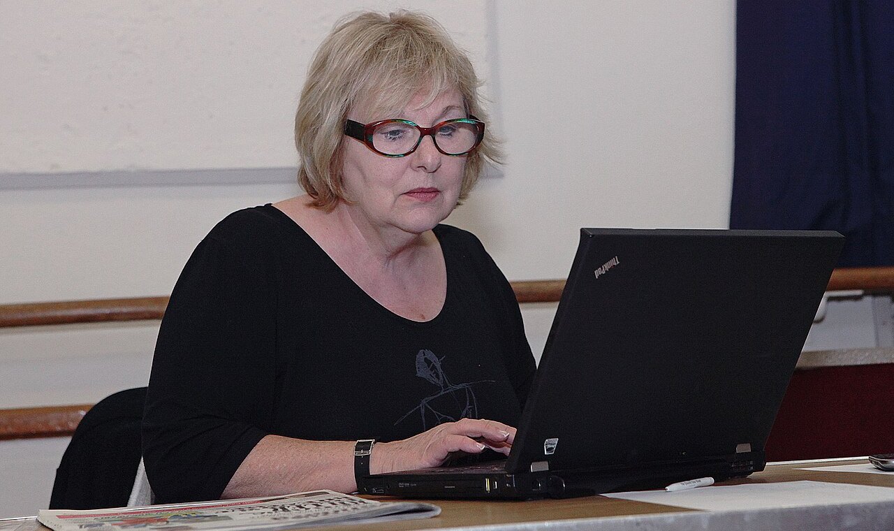 Frau mit Brille bei der Bildschirmarbeit am Laptop